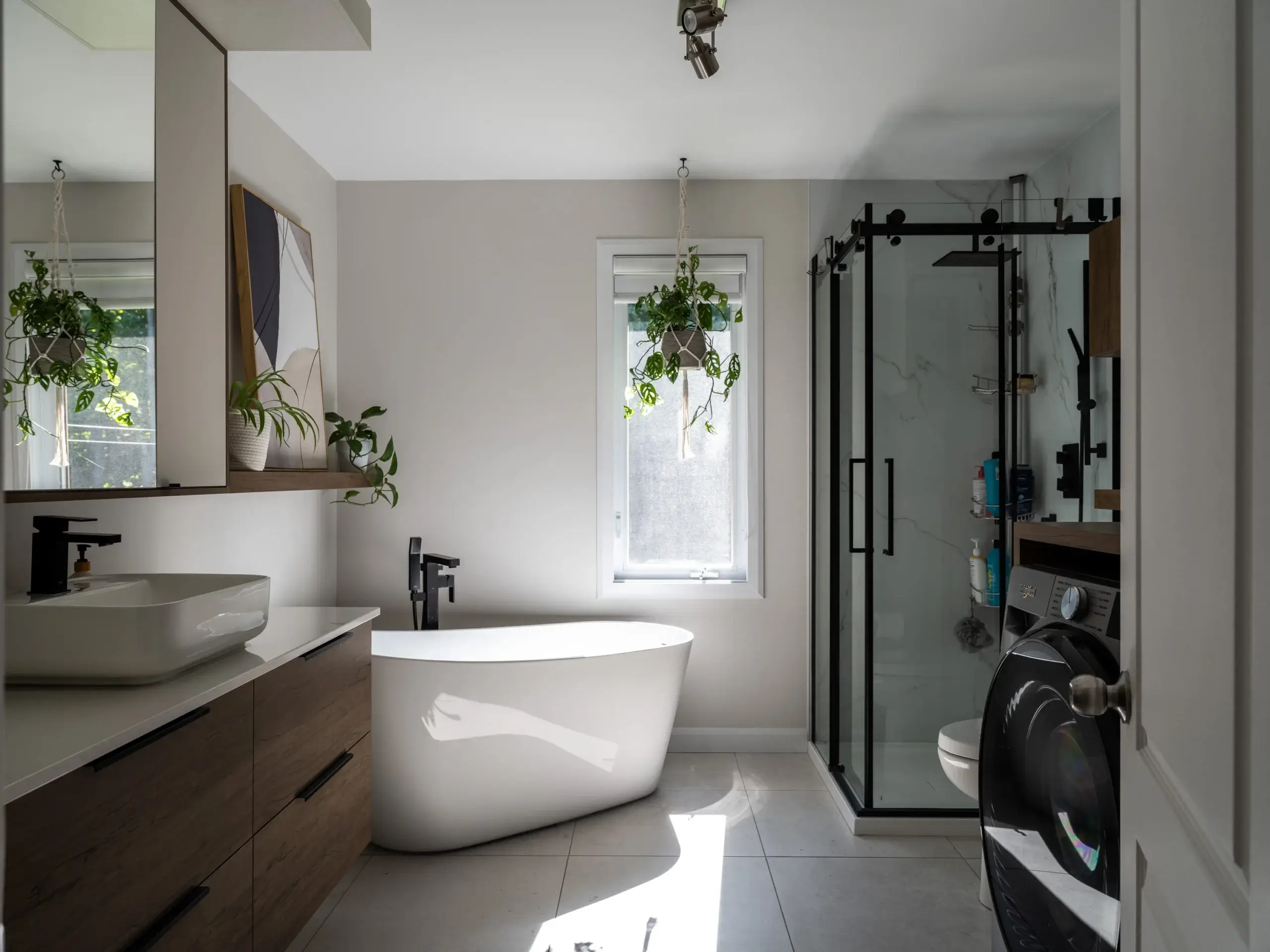 Salle de bain contemporaine à Montmagny avec vanité en bois sur mesure, baignoire autoportante et douche vitrée.